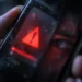 Alerta de seguridad reflejada junto al ojo de una persona en la pantalla del celular