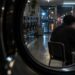 Persona desconocida consultando en secreto el perfil de otra persona desde una lavandería nocturna