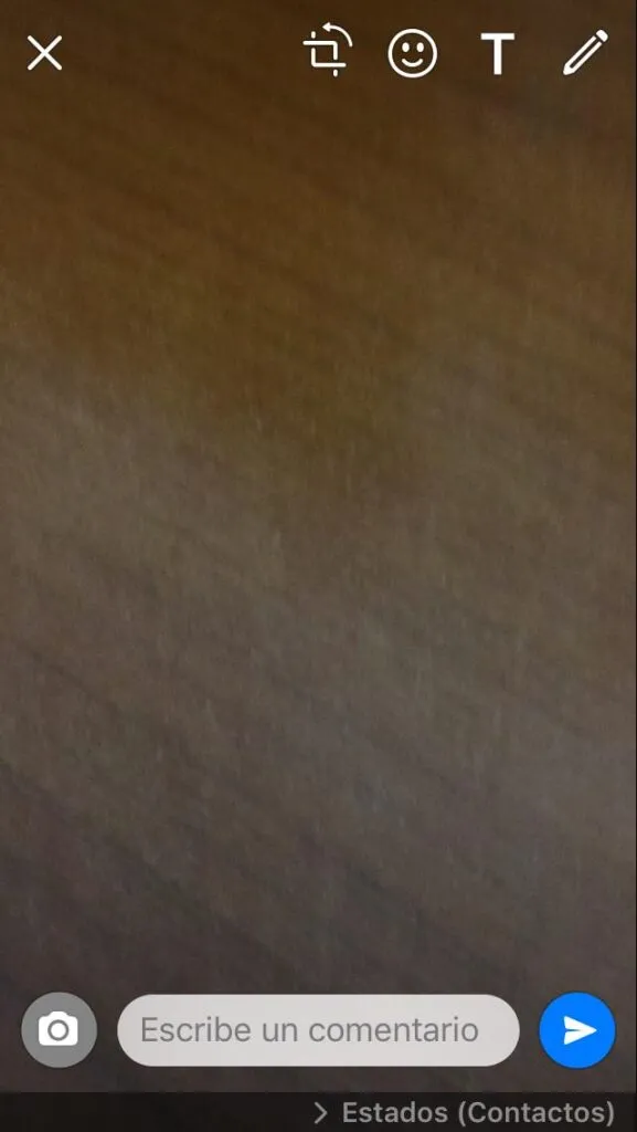 Cámara de un iPhone tomando una foto para un estado de WhatsApp, en donde se puede observar un icono en forma de avión de papel.