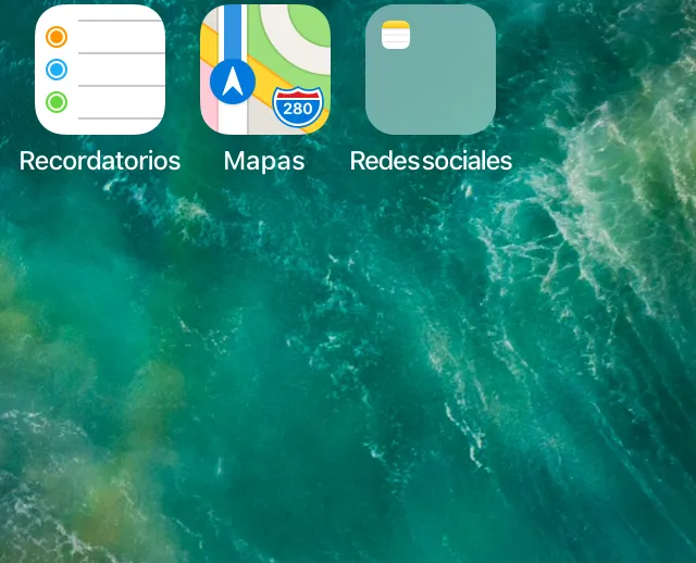 Pantalla de inicio de un iPhone en donde se puede observar que la app de WhatsApp está oculta, ya que se encuentra en la página dos de la carpeta “Redes sociales”.
